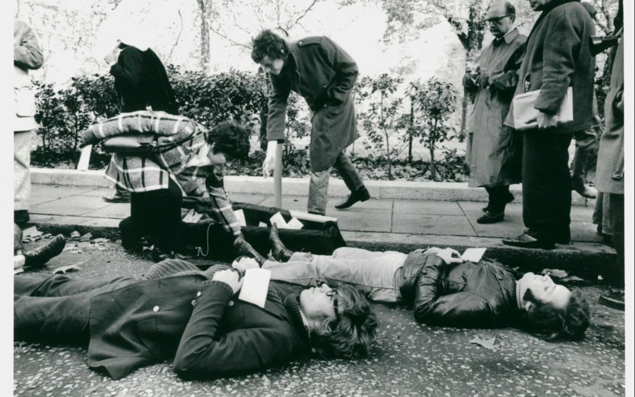 Black and white photo of students lying down on grass in protest