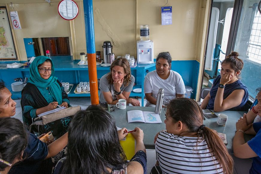 Photo by Sara Hylton, National Geographic
Groups meet in the common area of the M.V. Dinghy boat while traveling to Bhola district, the team's first site, on May 12, 2019. Through the expedition, the international, female-led team of scientists is working with National Geographic & partners.