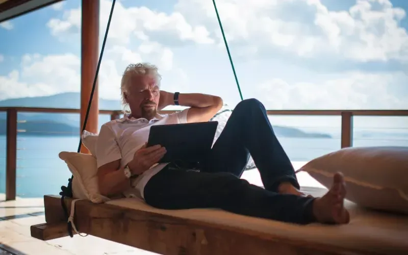 Richard Branson reading his iPad on a hammock on Necker Island 