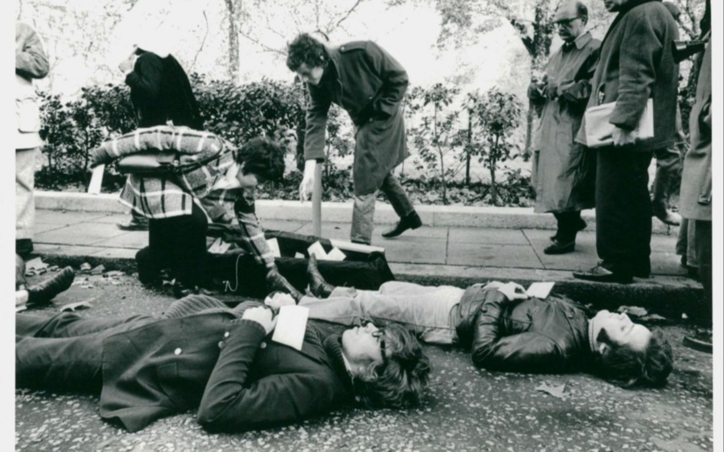 Black and white photo of a young Richard Branson and others lying down on the ground in protest