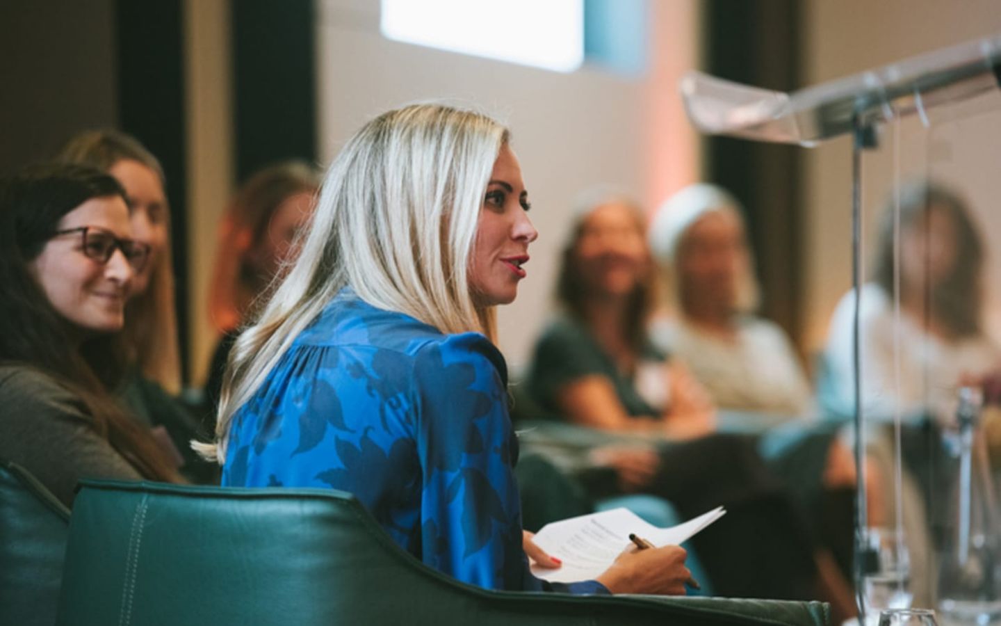 Holly Branson in a blue shirt talking to a panel of women