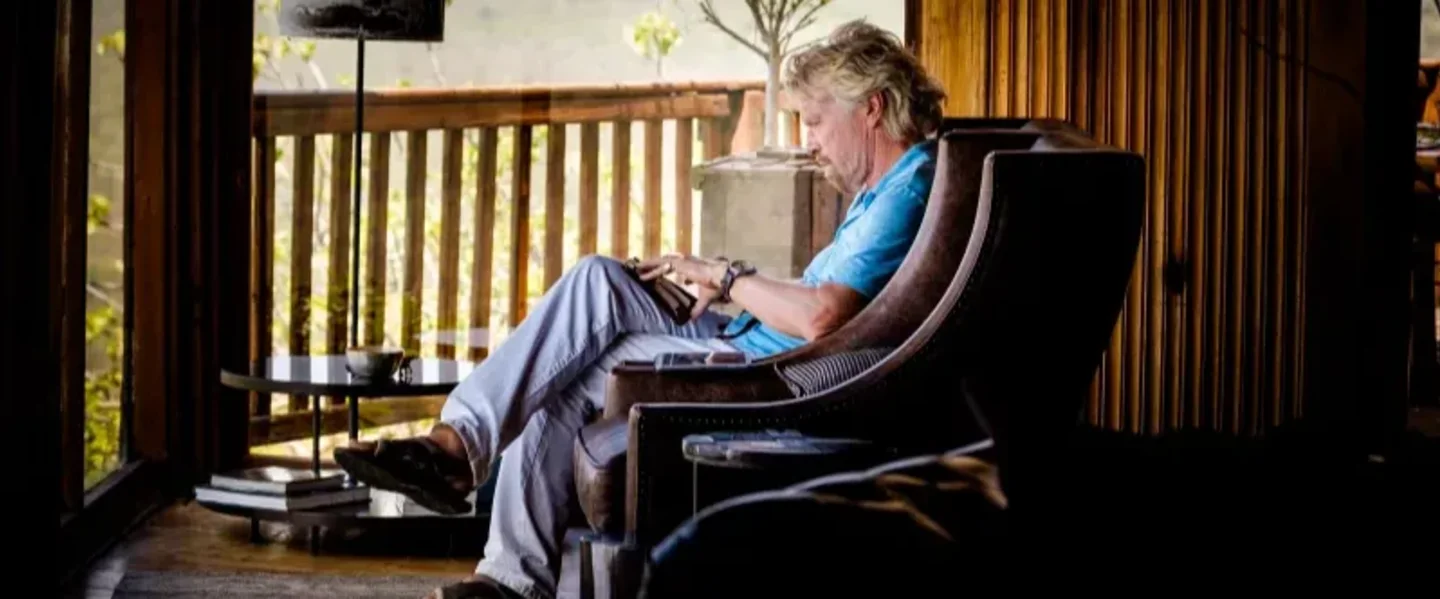 Richard Branson reading and taking notes on Necker Island