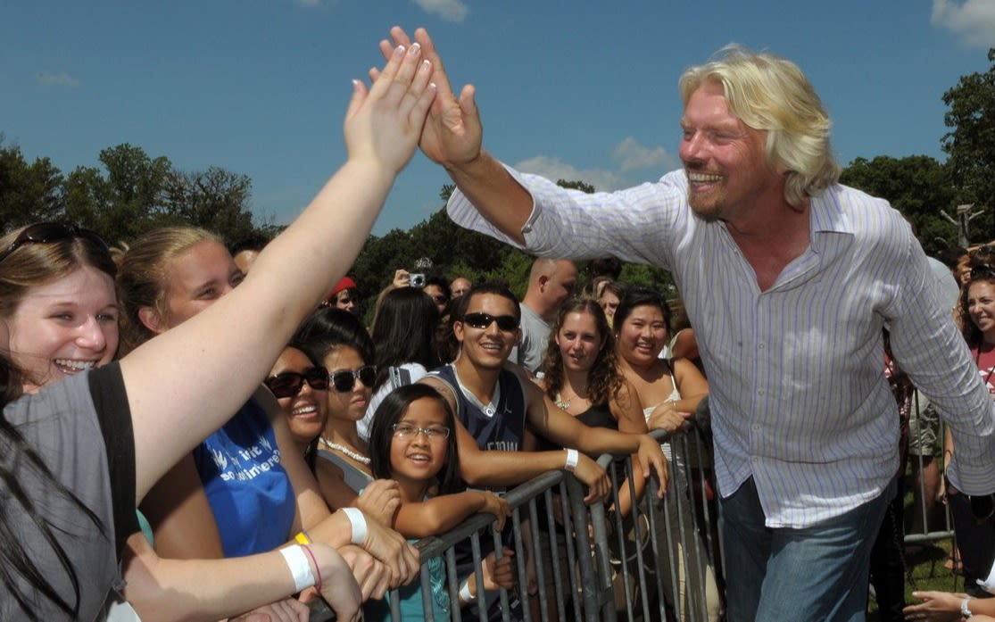 Richard Branson giving someone in a crowd a high five