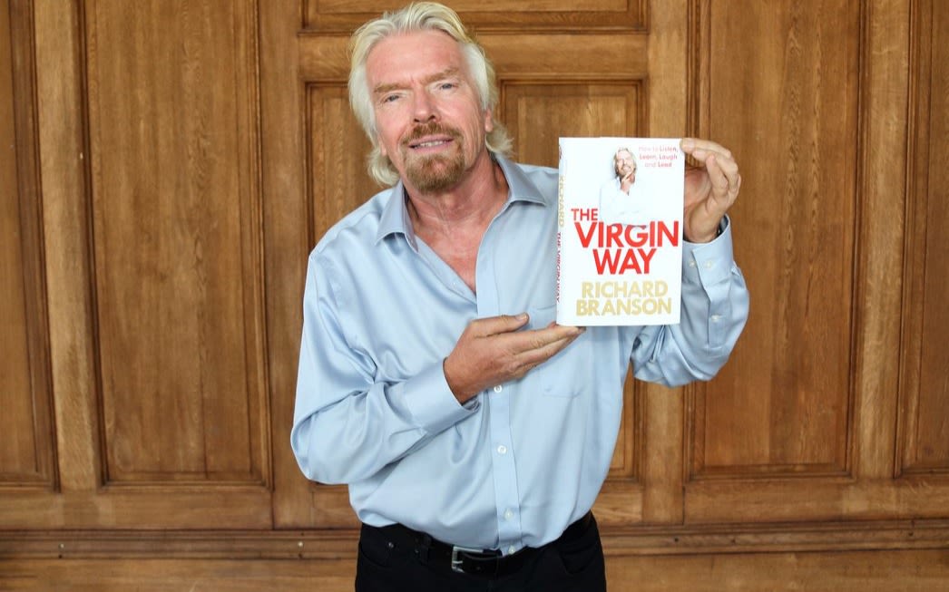 Richard Branson holding a copy of his book - The Virgin Way