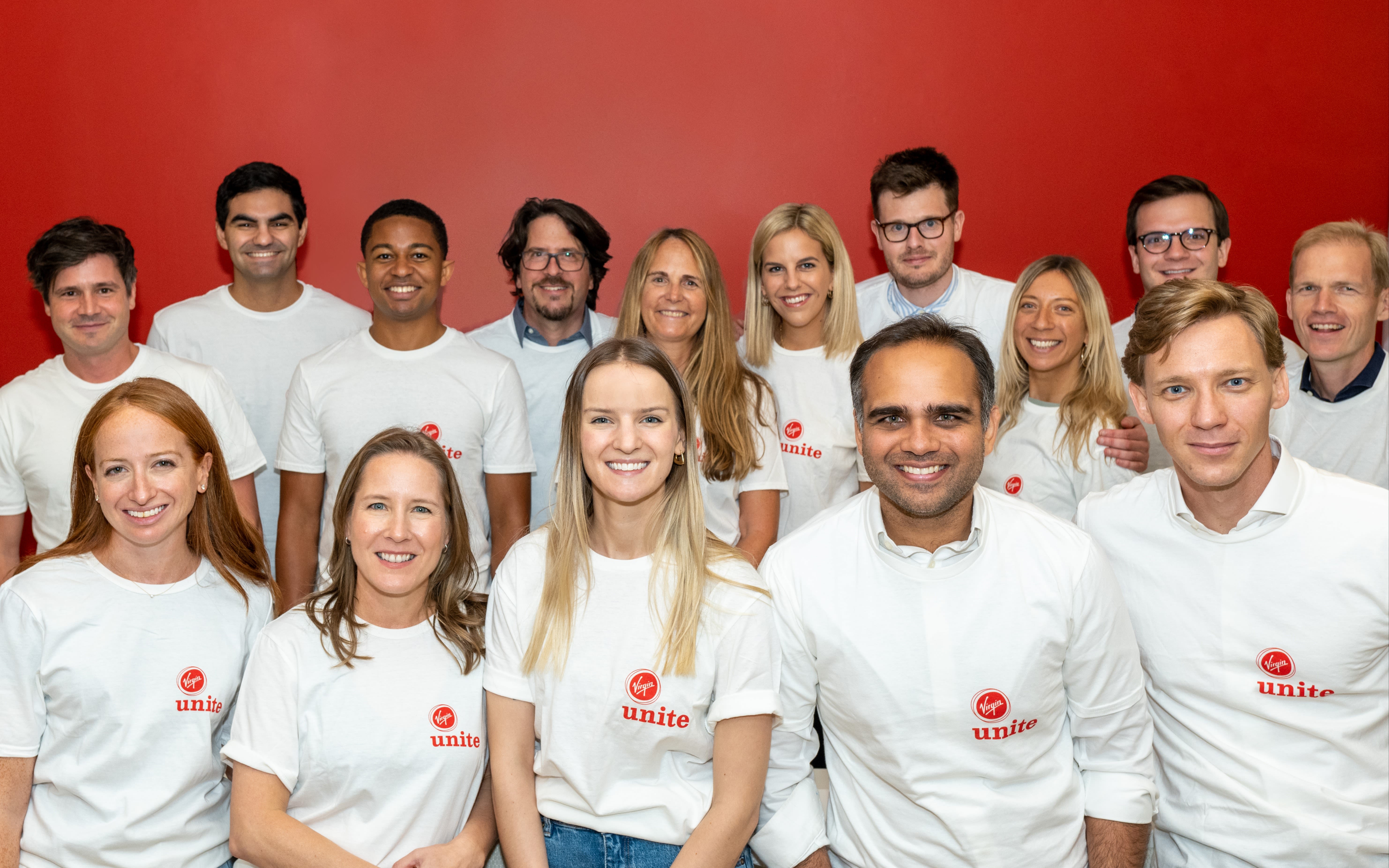 15 Virgin Unite team members wearing white t-shirts with the red Virgin Unite logo on them