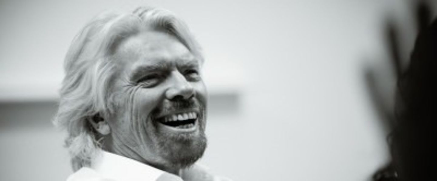 Black and white close up photo of Richard Branson laughing