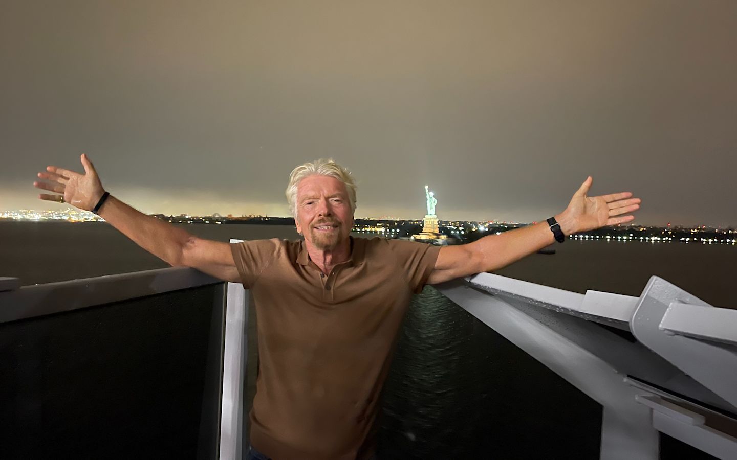 Richard Branson standing onboard Virgin Voyages as it sails into New York