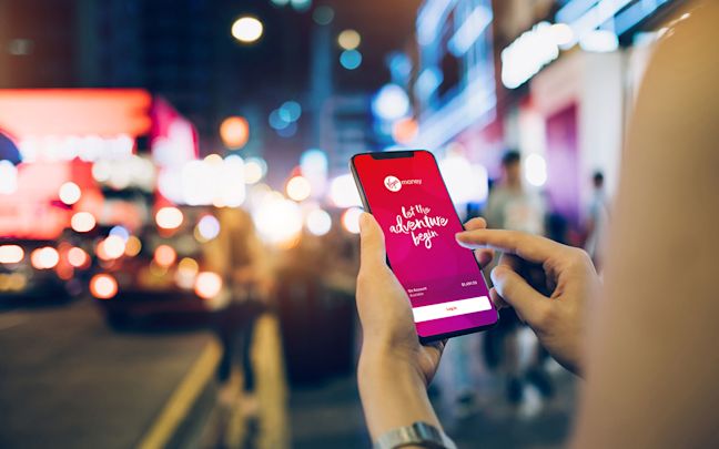 A person holding a phone showing the Virgin Money Australia app A person holding a phone showing the Virgin Money Australia app