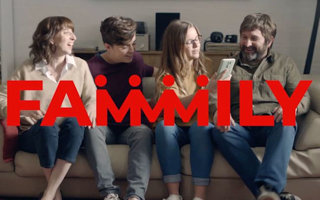 A family sitting on a sofa together. Text reads: Fammmily A family sitting on a sofa together. Text reads: Fammmily