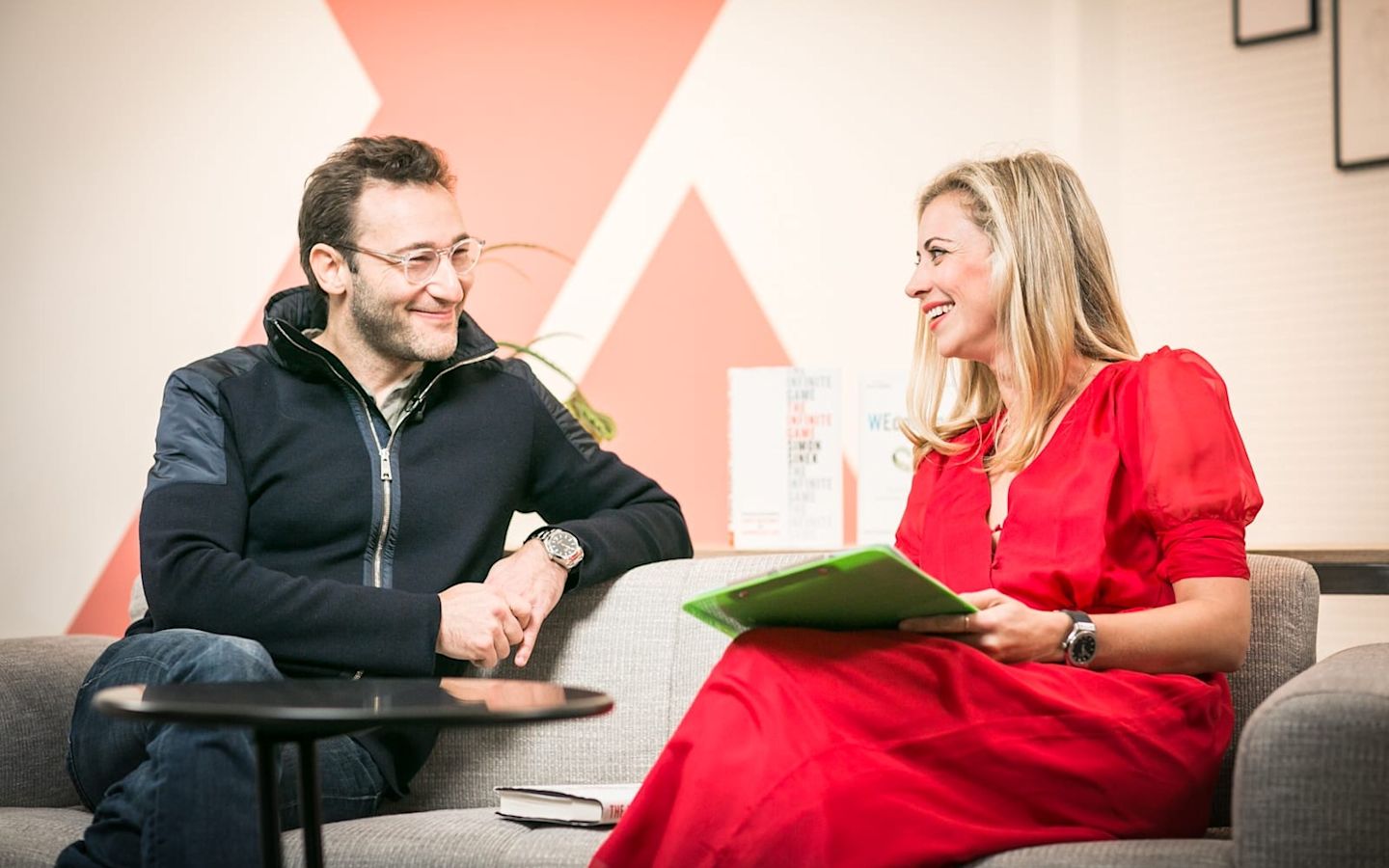 Holly Branson and Simon Sinek sitting on a sofa chatting