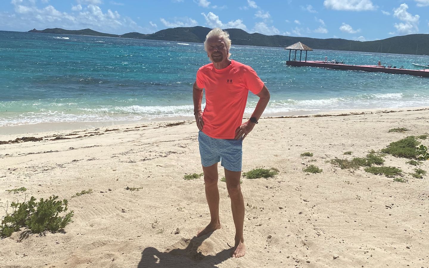 Richard Branson standing on the beach about to go for a swim