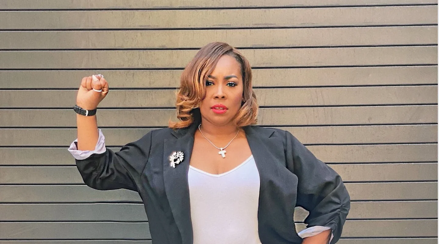 Topeka K. Sam poses with her right fist in the air