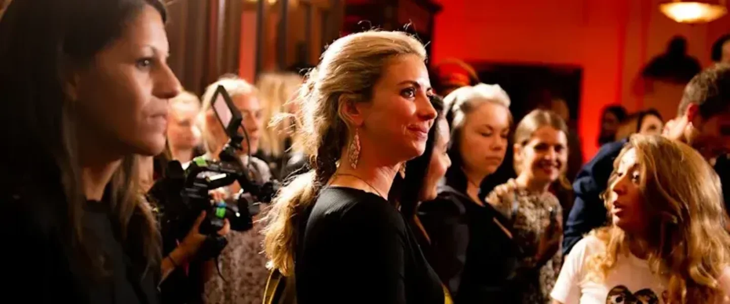 Holly Branson smiling in a black dress at the Virgin Voyages uniform launch party in London