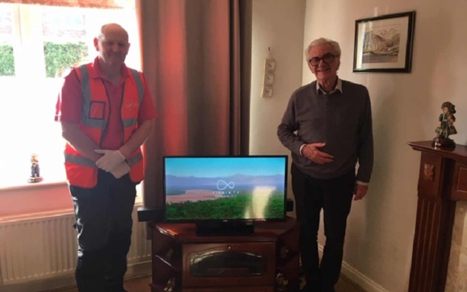 Virgin Media Employee meets a customer standing next to a television