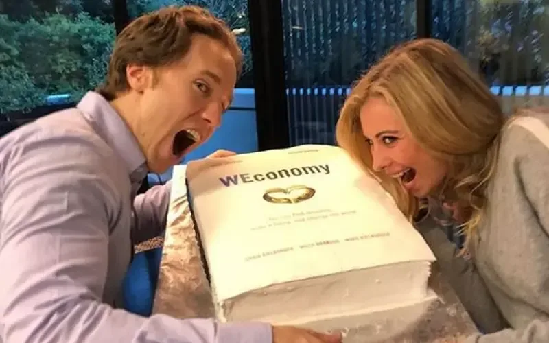 Holly with Craig Kielburger pretending to bite into a WEconomy cake