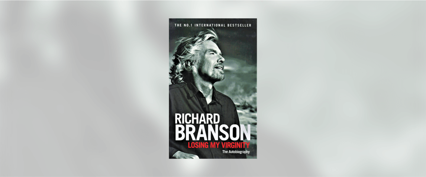 A black white picture of Richard Branson staring into space on a cover of a book called "Loosing My Virginity"