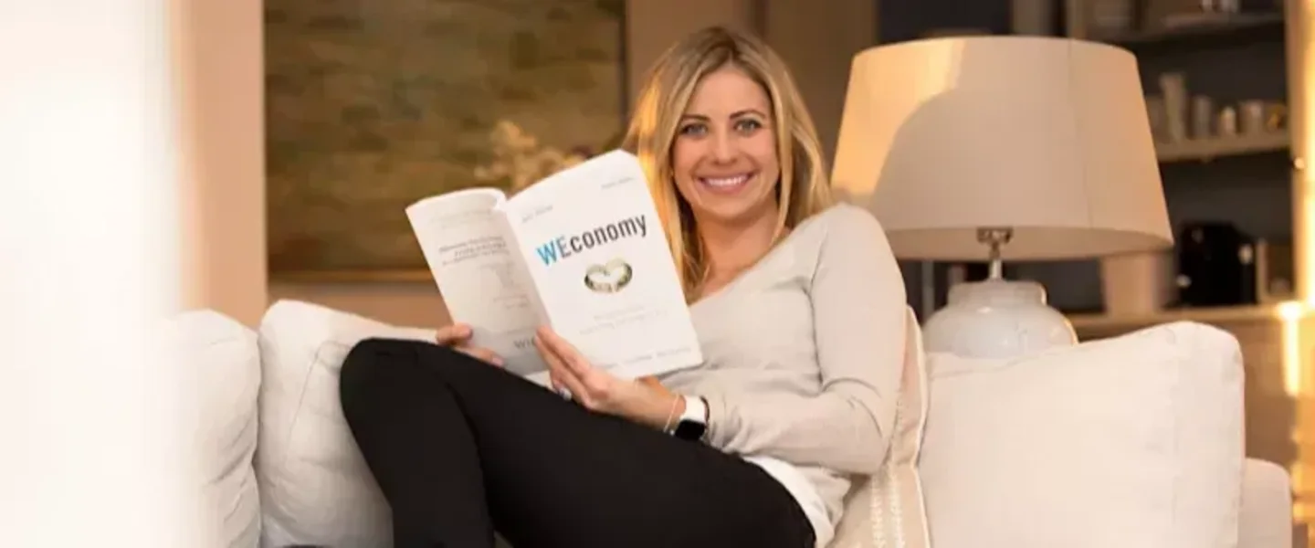 Holly Branson on sofa with a copy of WEconomy