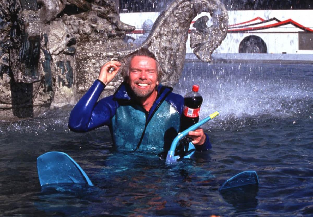 Richard Branson swims in a fountain with a Virgin Cola bottle