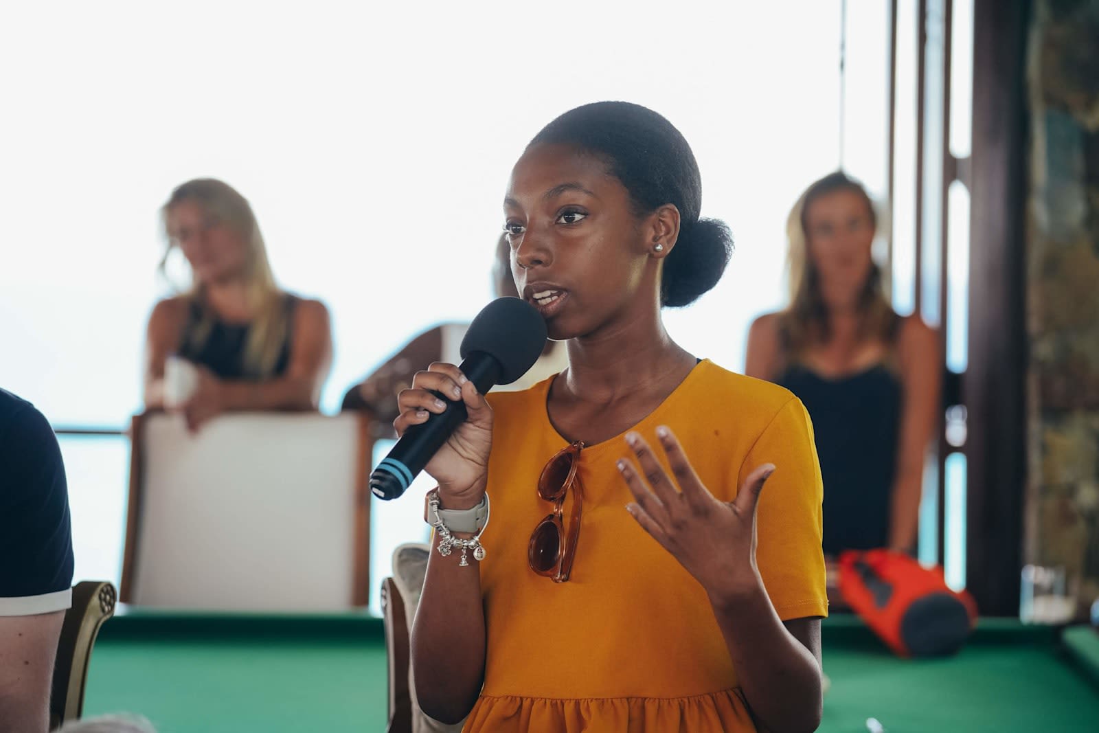 Tatiana holding a mic and speaking at a Virgin Unite gathering on Necker Island