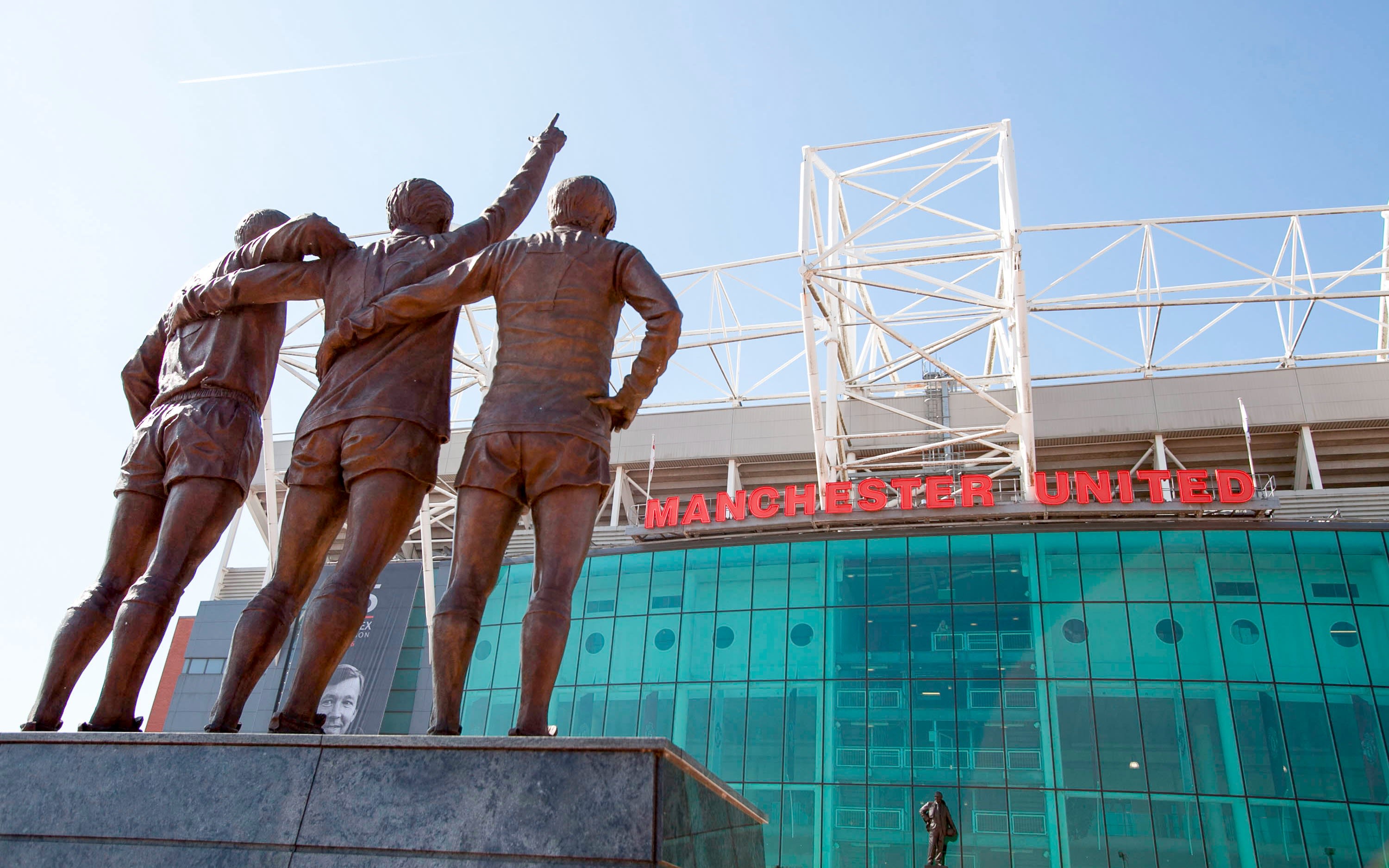 The statue of three people outside Old Trafford stadium in Manchester