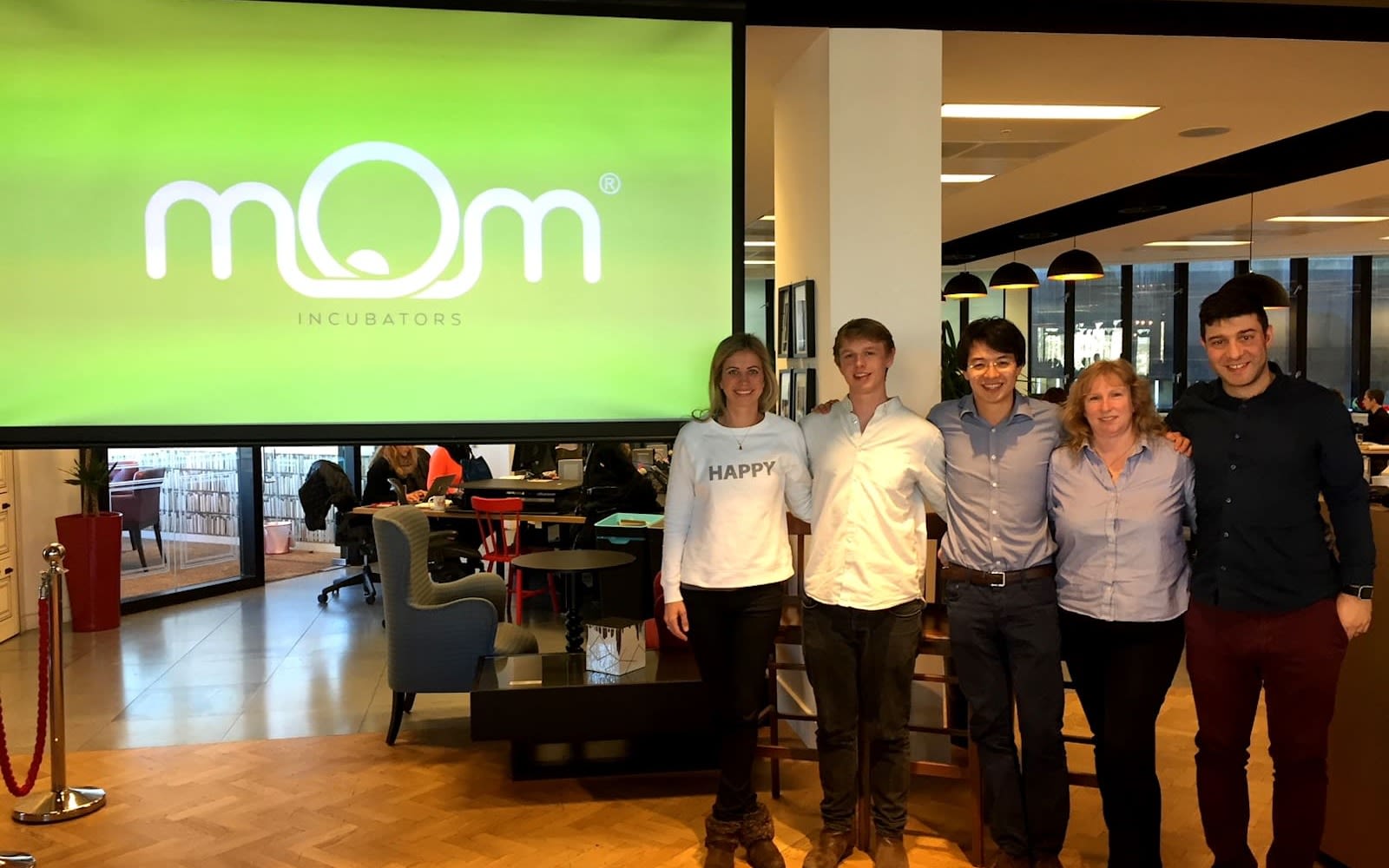 Founders of MOM with Holly Branson in front of a screen with the Mom logo 