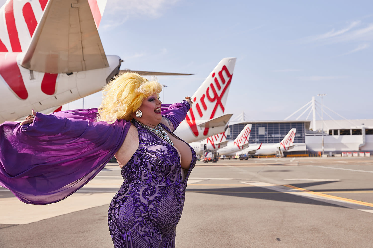 A drag queen posing next to Virgin Australia aircraft