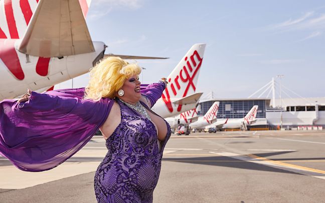 A drag queen posing next to Virgin Australia aircraft A drag queen posing next to Virgin Australia aircraft