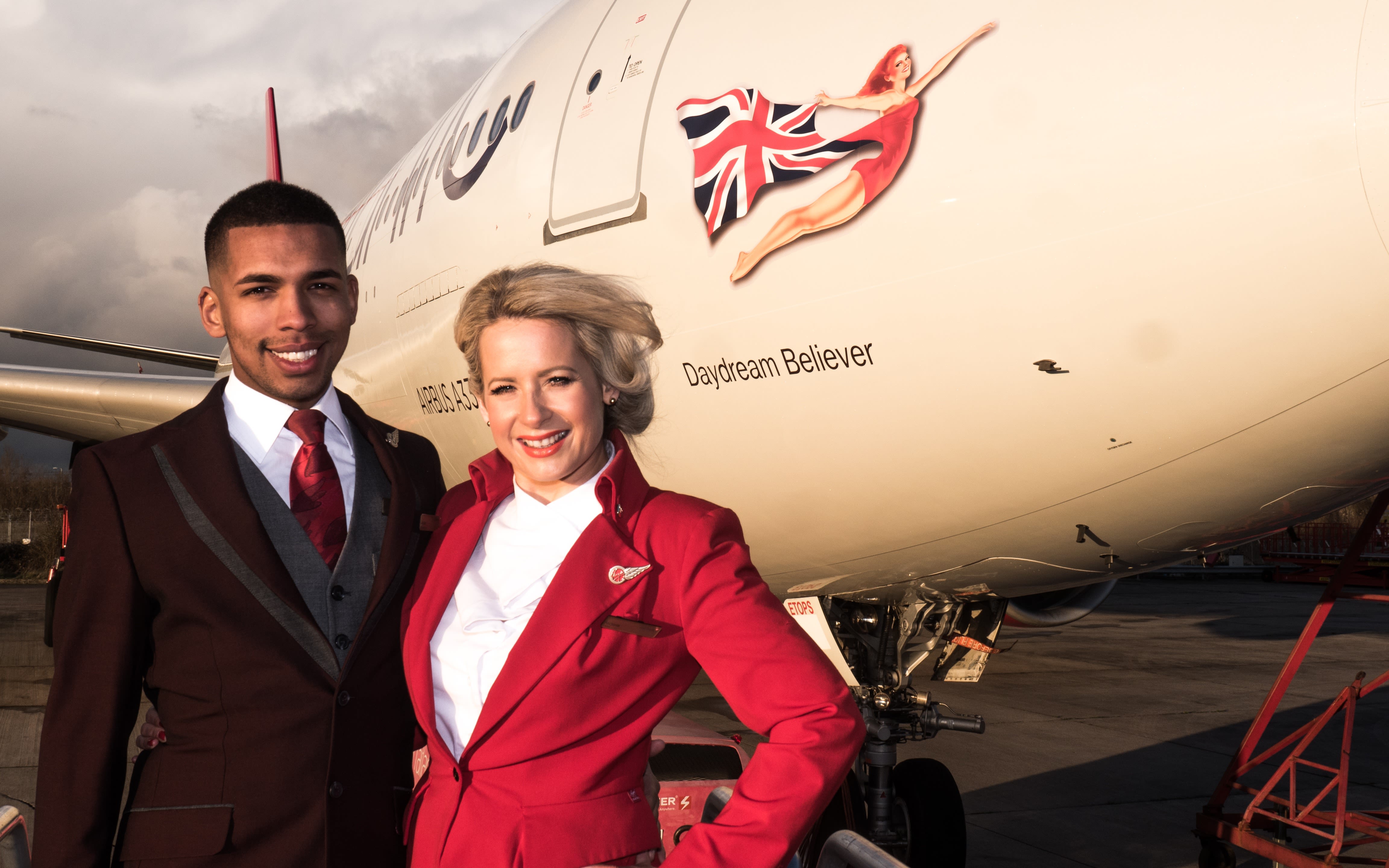 Two members of Virgin Atlantic cabin crew stand in front of Daydream Believer, an Airbus A330 aircraft