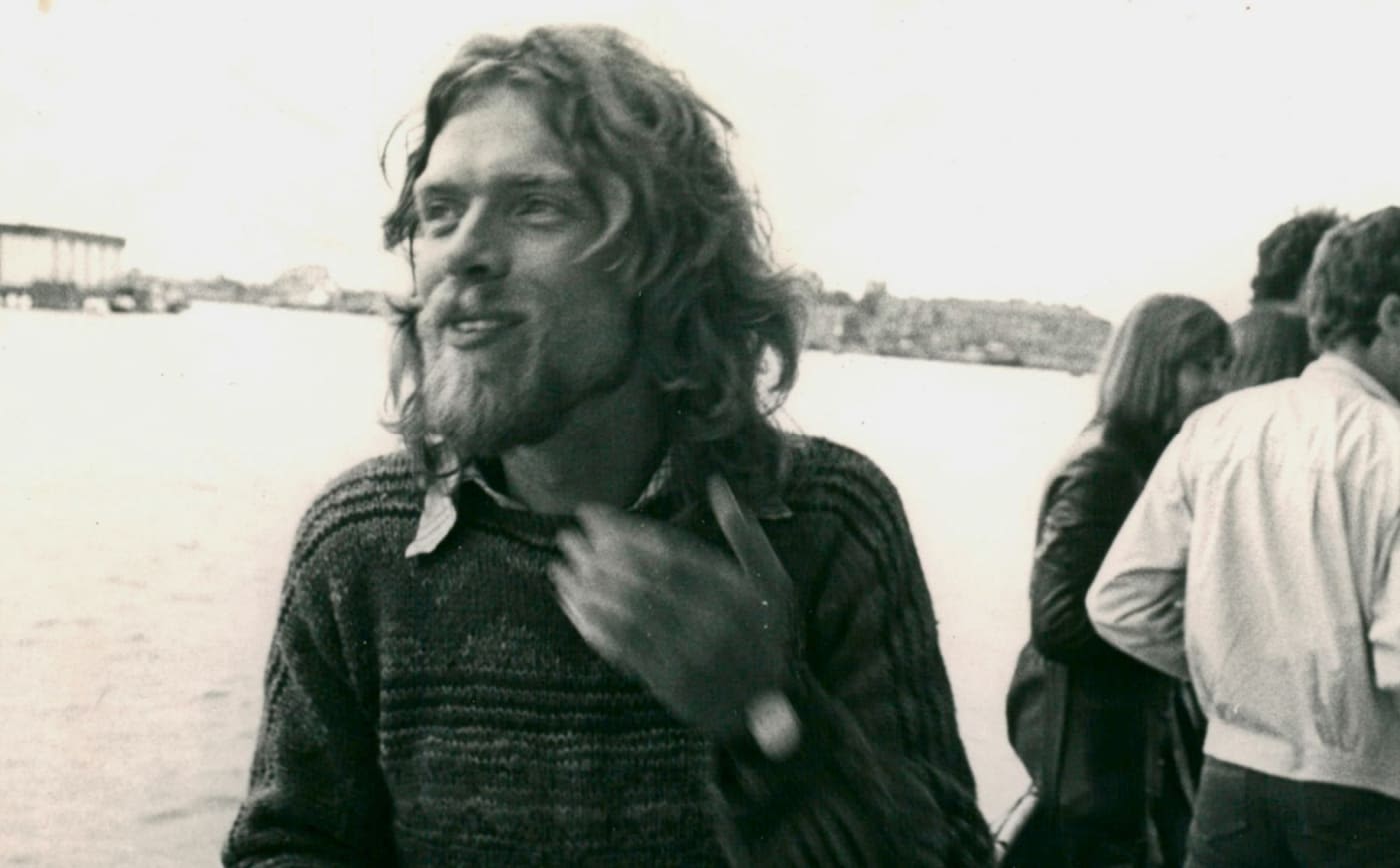 A black and white image of Richard Branson with long hair and a beard
