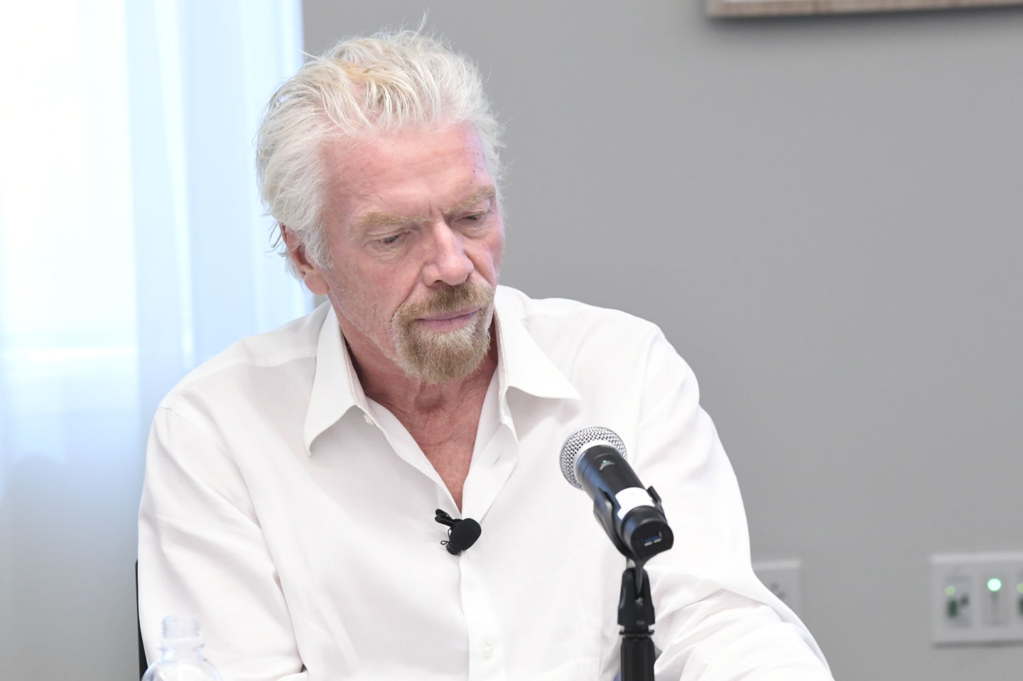 Richard Branson wearing a white shirt at a panel discussion