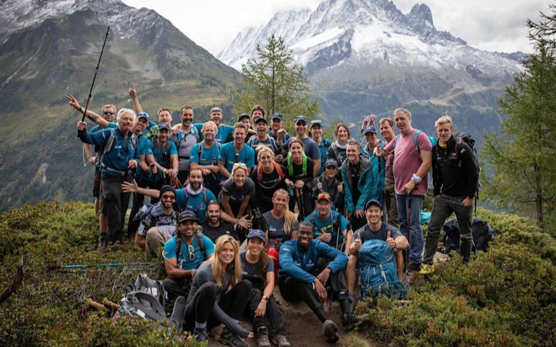 Richard Branson with a team of hikers with mountains behind them 