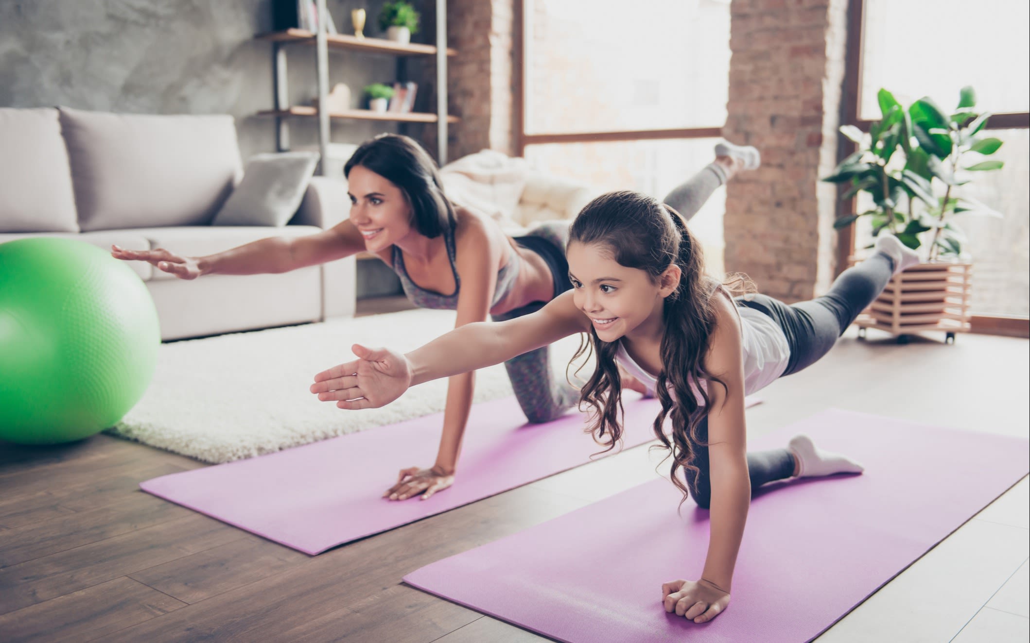 A woman and her daughter practising yoga at home