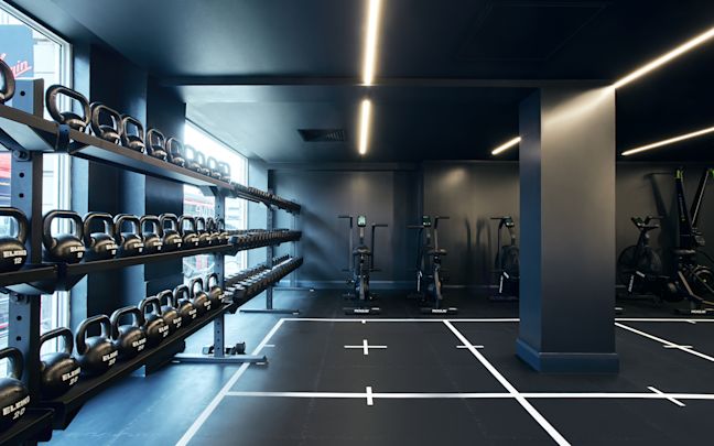 Gym floor with kettle bells on the left hand side and ergonomic bikes in the background Gym floor with kettle bells on the left hand side and ergonomic bikes in the background