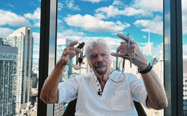 Richard Branson in New York City holding up Made51 ornaments made by refugees