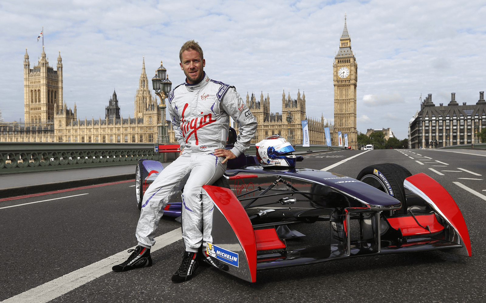 Envision Virgin Racing driver Sam Bird sits on his Formula E car in front of Big Ben and the Palace of Westminster 