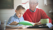 Older person reading a book with a young child