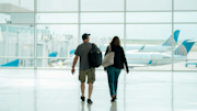 Couple (man and woman) seen from behind with luggage in airport