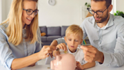 Family putting money in a piggy bank