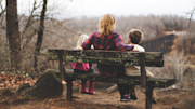 Person sitting on a bench with two children