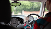 Young male driver at the wheel of a car.