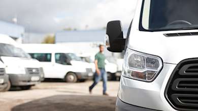 Male worker walking to the rear of a white van.