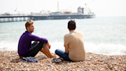Two people sat on a beach