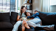 Mother cuddling on the sofa with two children
