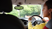 Person driving with both hands on the steering wheel