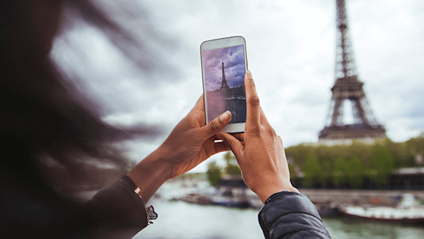 Young woman taking photo of eiffel tower