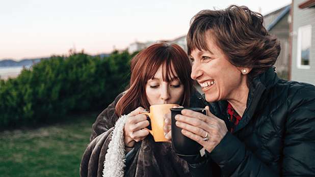 Mum and daughter drinking a hot drink outdoors