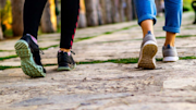 Two people walking on a path, focusing on their shoes.