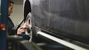 Person checking the tyres on a car