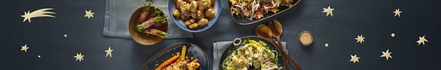 Kerst bijgerechten op een gedekte tafel.