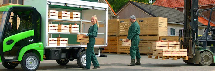 Boeren laden lokaal geteelde producten in bij een boerderij.